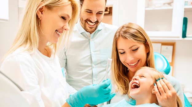 Family having dental treatment child sit on dental chair and smiling